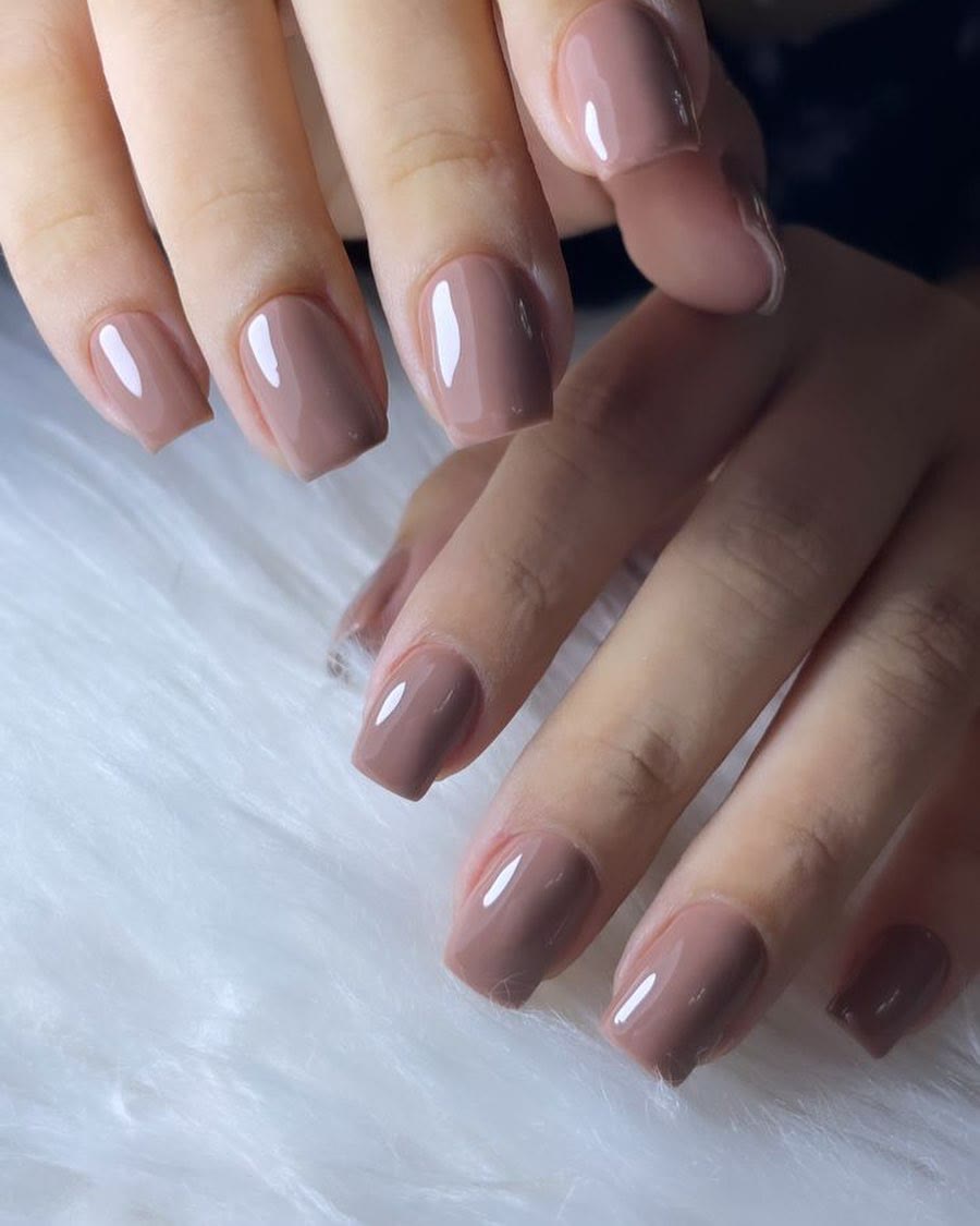 Mauve gel nails on a white fur throw