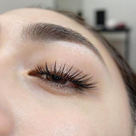 A closed eye with long, natural-looking eyelash extensions